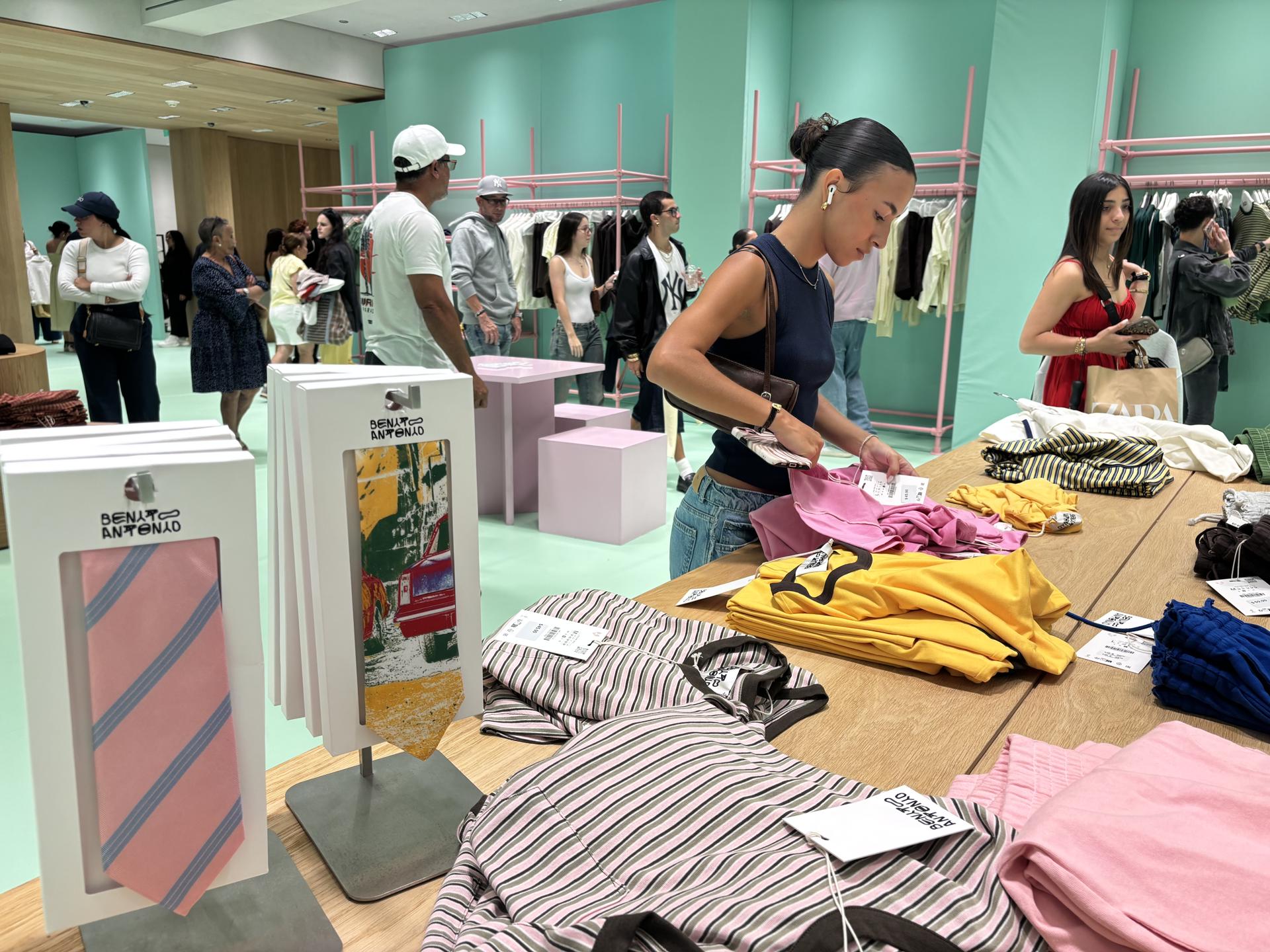 Personas observan las prendas de la nueva colección exclusiva 'Benito Antonio' este martes, en la tienda de la marca española Zara en el centro comercial Plaza Las Américas de San Juan (Puerto Rico). Camisetas, pantalones, corbatas y trajes en tonos cálidos y colores pastel, rodeados de mesas con juegos de dominó, proyectan el ambiente caribeño de Puerto Rico en la nueva colección exclusiva 'Benito Antonio' de Bad Bunny y Zara, que ya triunfó en San Juan y llegará el 21 de mayo a otros países. EFE/ Esther Alaejos
