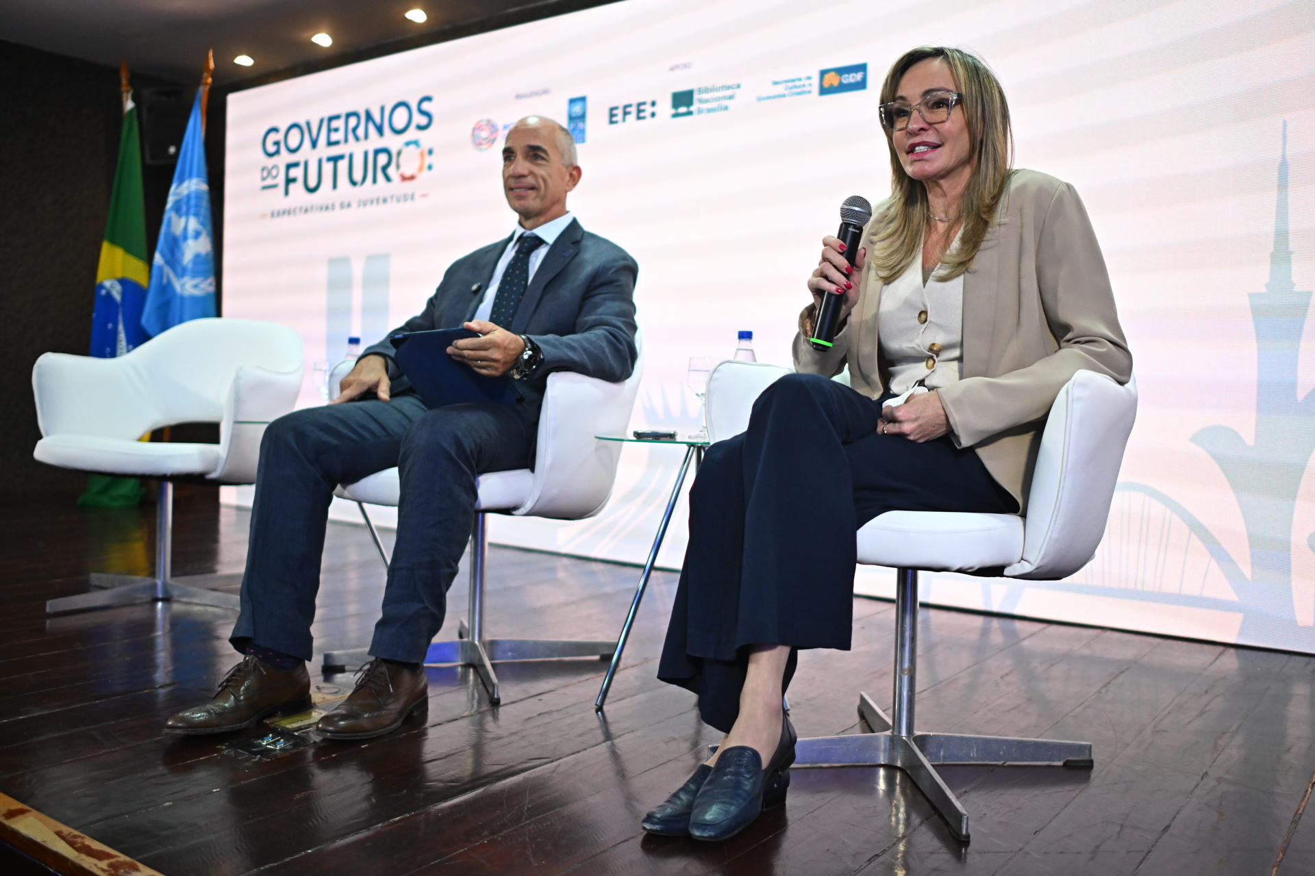 La directora de Negocios para América del Sur de EFE, Nuria Engelmo (d), habla junto del representante residente del PNUD en Brasil, Claudio Providas, durante el evento 'Gobiernos del Futuro: Expectativas de la Juventud' este miércoles, en la Biblioteca Nacional de Brasilia (Brasil). EFE/ André Borges
