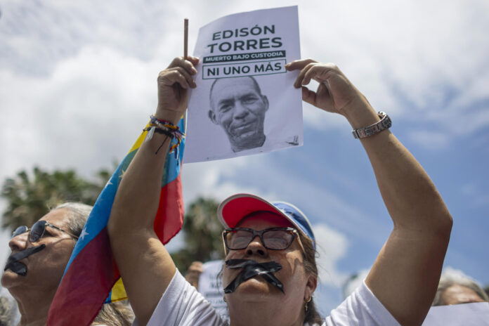 Una persona sostiene un cartel durante una manifestación silenciosa para exigir justicia y la libertad de los presos políticos este miércoles, en Caracas (Venezuela). EFE/ Miguel Gutiérrez
