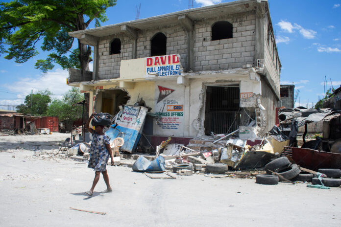 Una mujer camina con pocas pertenencias tras enfrentamientos entre grupos armados en Puerto Príncipe (Haití). EFE/ Jonet St Élois
