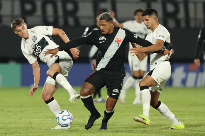 Juan Fernando Alfaro (i) y Mateo Gamarra (d), de Olimpia, disputan un balón con David Corrêa, de Vasco da Gama, este miércoles en un partido de la Copa Sudamericana en el estadio Defensores del Chaco, en Asunción. EFE/ Juan Pablo Pino
