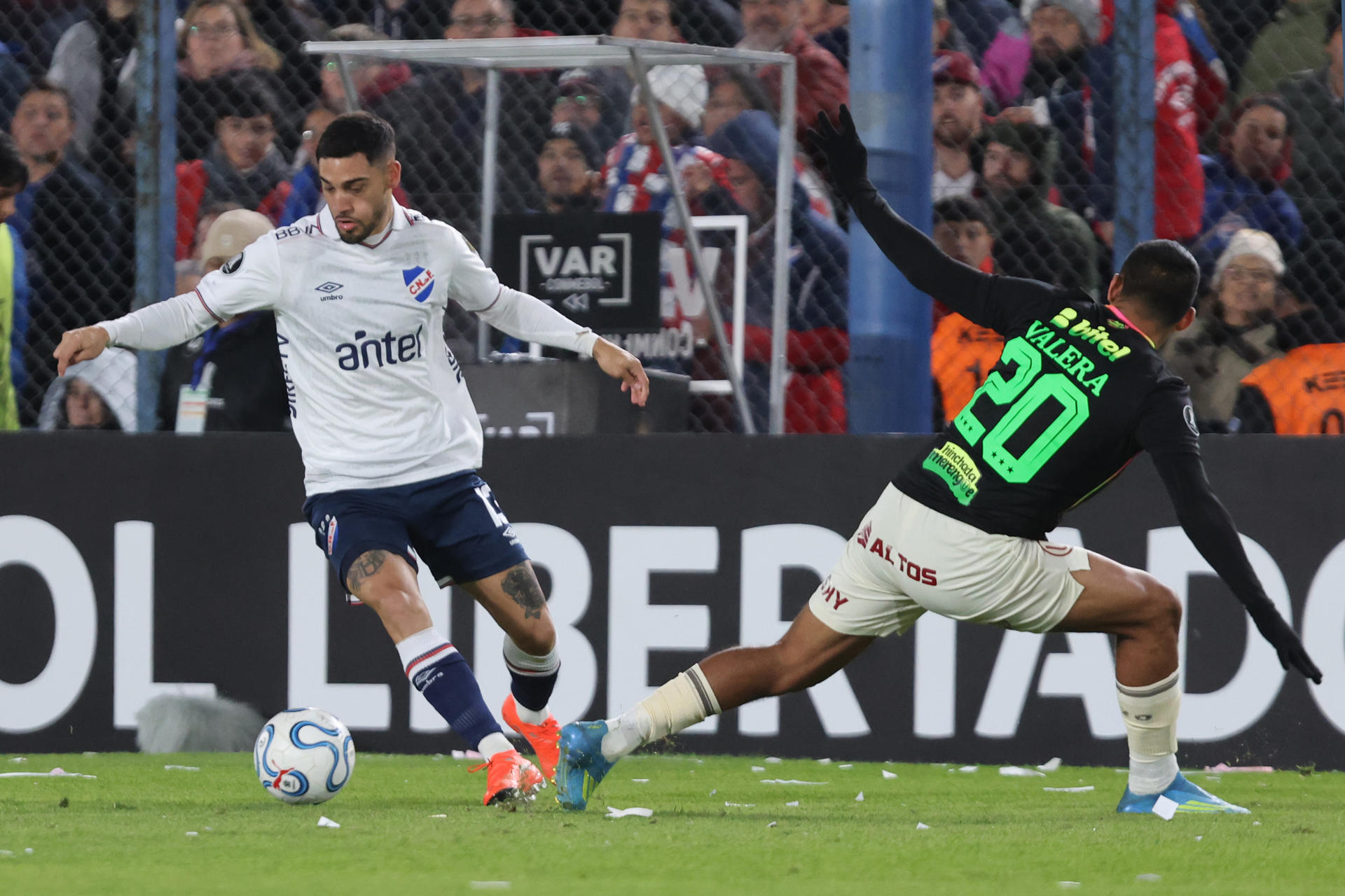 Emiliano Ancheta (i), de Nacional, disputa un balón con Alex Valera, de Universitario, en un partido de la fase de grupos de la Copa Libertadores entre el Club Nacional y Universitario de Deportes en el estadio Gran Parque Central en Montevideo (Uruguay). EFE/Gastón Britos
