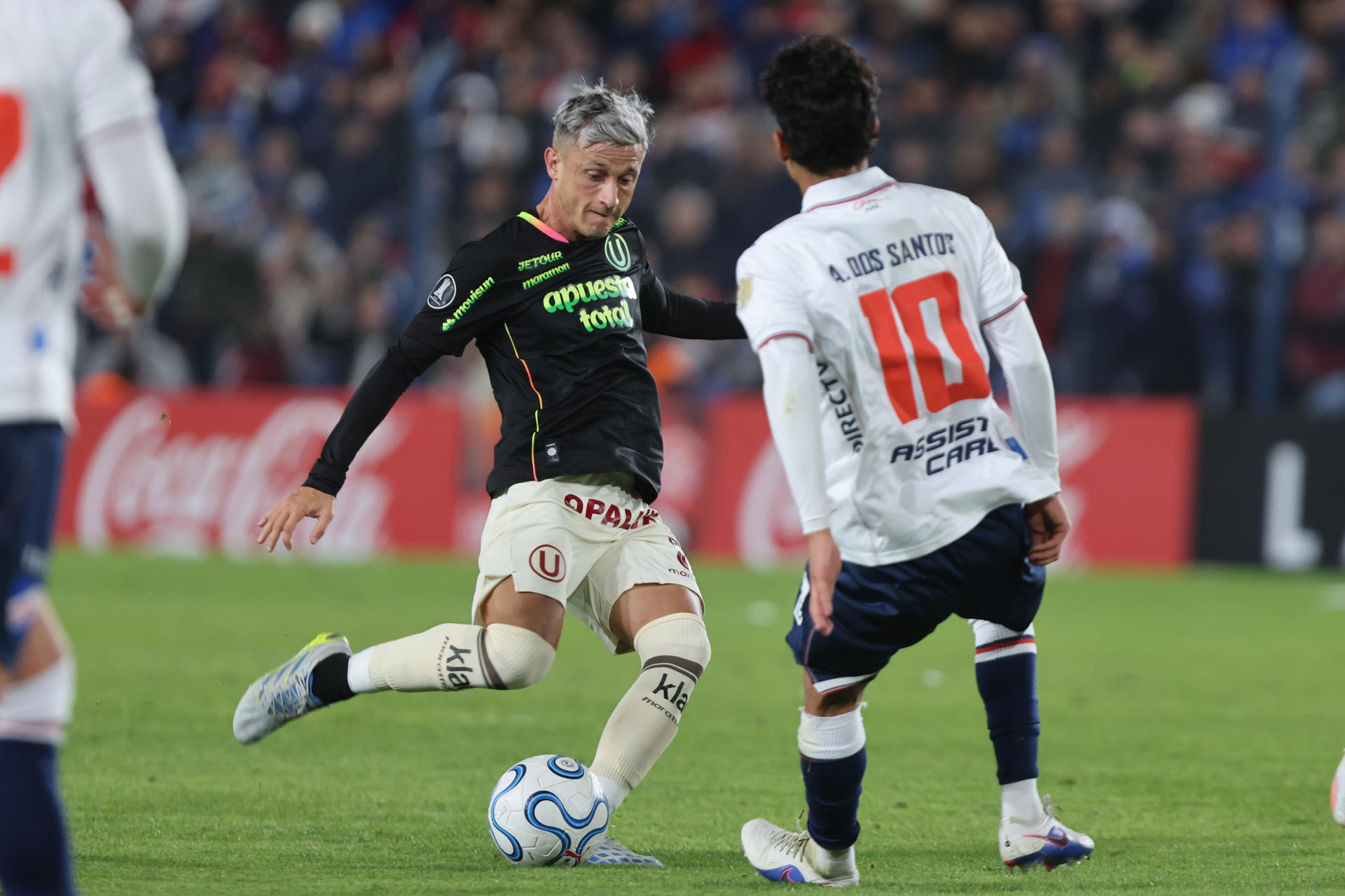 Alexander dos Santos (d), de Nacional, disputa un balón con Hector Fértoli, de Universitario, en un partido de la fase de grupos de la Copa Libertadores entre el Club Nacional y Universitario de Deportes en el estadio Gran Parque Central en Montevideo (Uruguay). EFE/ Gastón Britos

