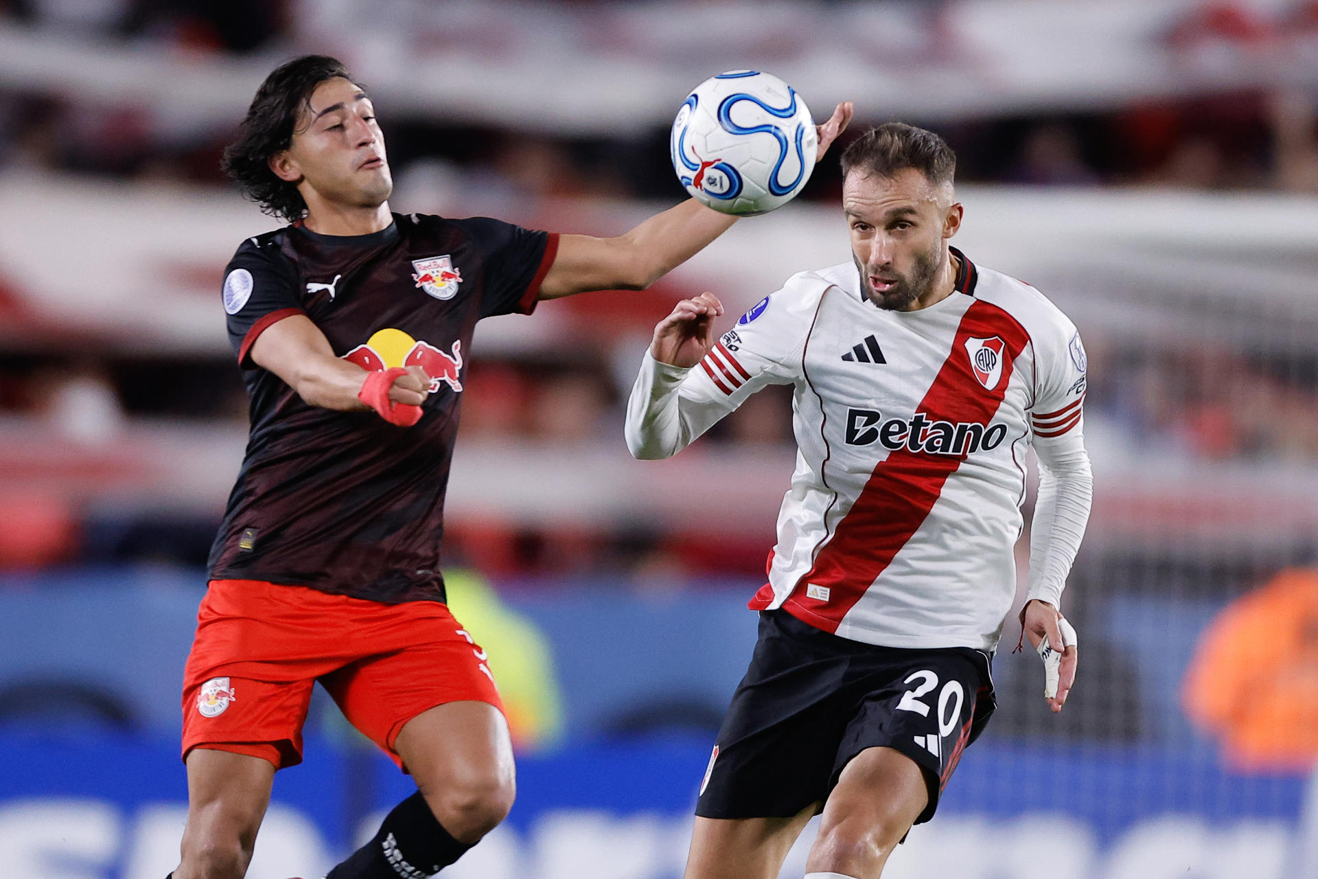 German Pezzella (d), de River Plate, disputa el balón con José Herrera, de Bragantino, en el estadio Monumental de Buenos Aires. EFE/Juan Ignacio Roncoroni

