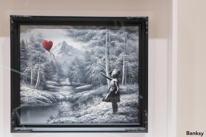 Fotografía del óleo del artista Banksy que representa a una niña a la que se le escapa un globo rojo con forma de corazón este martes, en Nueva York (EE.UU.). EFE/ Ángel Colmenares
