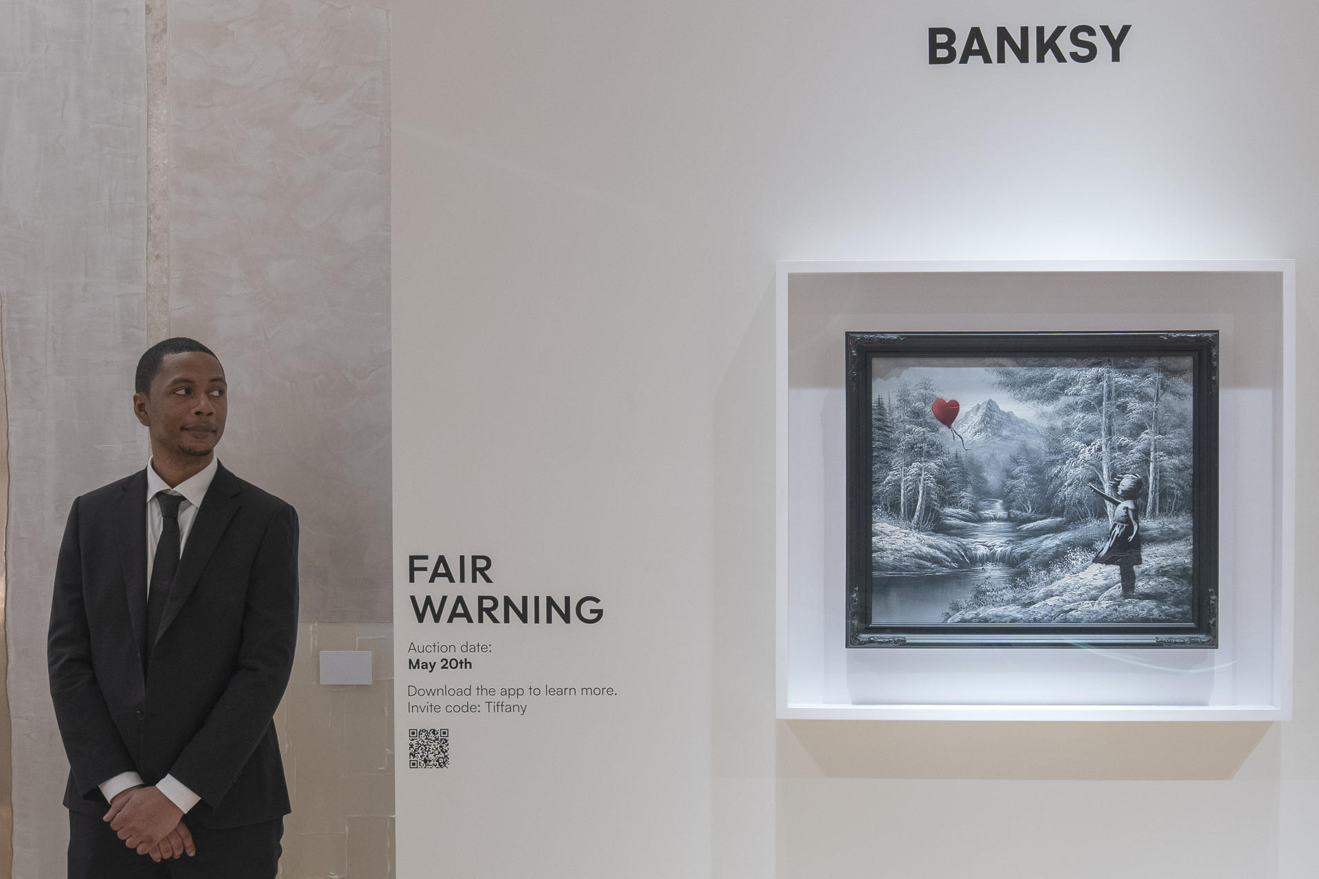 Un hombre observa el óleo del artista Banksy que representa a una niña a la que se le escapa un globo rojo con forma de corazón este martes, en Nueva York (EE.UU.). EFE/ Ángel Colmenares
