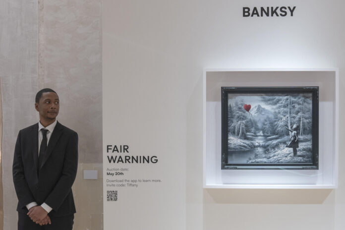 Un hombre observa el óleo del artista Banksy que representa a una niña a la que se le escapa un globo rojo con forma de corazón, en Nueva York (EE.UU.). EFE/ Ángel Colmenares
