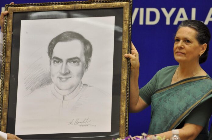 La presidenta del Partido del Congreso de la India, Sonia Gandhi, posa con un retrato de su marido, el exprimer ministro Rajiv Gandhi, en un acto en Nueva Delhi en septiembre de 2010.
