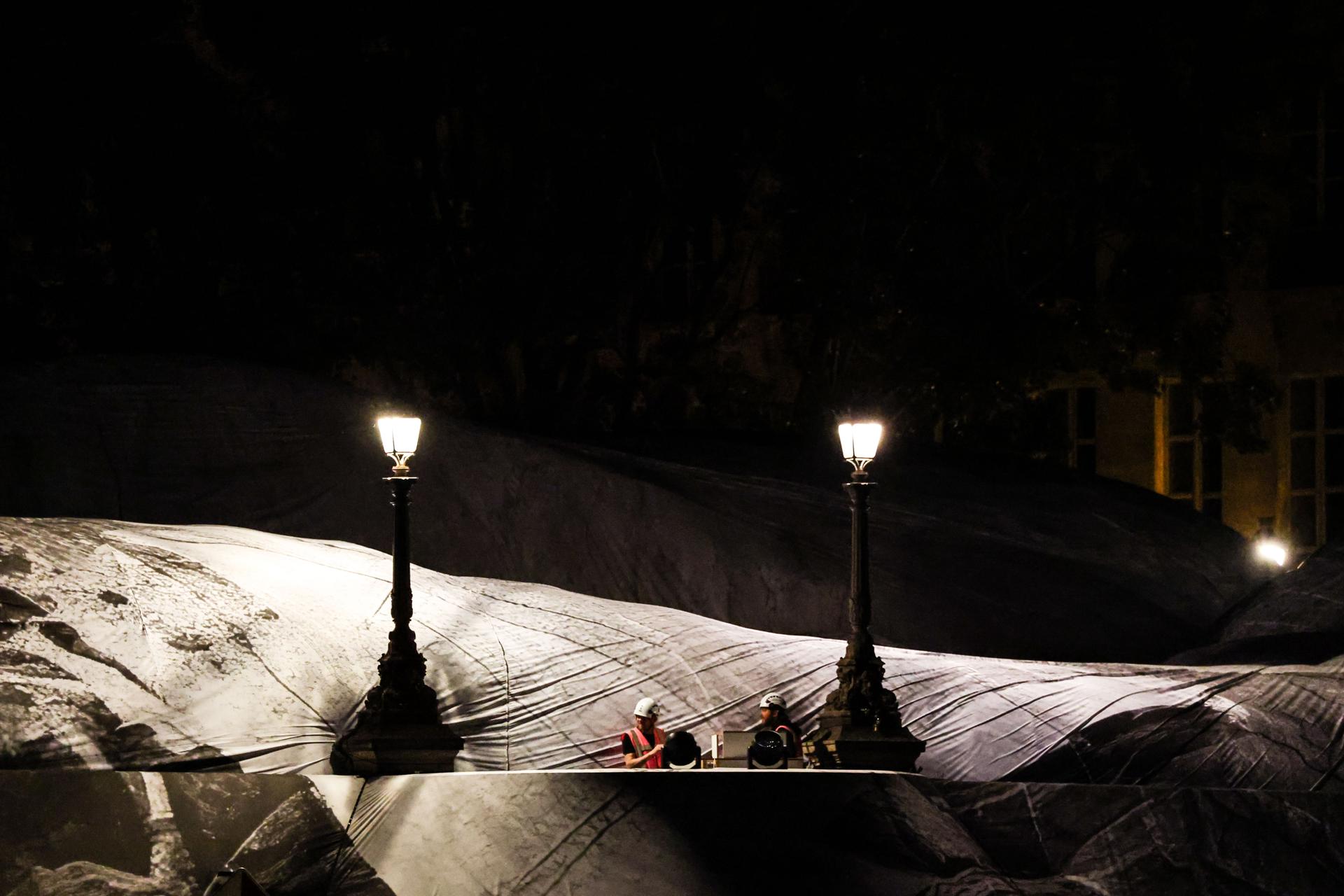 Obreros trabajan en la instalación "La Caverne du Pont Neuf" del fotógrafo y artista callejero francés JR en París, Francia, la madrugada de la noche de este miércoles 20 de mayo de 2026. La obra estará expuesta del 6 al 28 de junio de 2026 y rendirá homenaje a "El Pont Neuf envuelto" de los artistas Christo y Jeanne-Claude. (Francia) EFE/EPA/MOHAMMED BADRA
