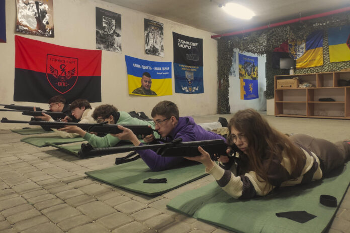 Estudiantes ucranianos de entre 15 y 17 años adquieren habilidades básicas en el manejo de armas bajo la supervisión de instructores con experiencia en combate este jueves, en una escuela de Leópolis (Ucrania). A medida que la invasión rusa se acerca a su 52º mes, las escuelas secundarias ucranianas están pasando de las clases teóricas a la preparación militar práctica, con instructores con experiencia en combate que enseñan a los adolescentes habilidades básicas de combate y supervivencia. Más de 13.000 estudiantes de entre 15 y 17 años asisten a clases en más de una docena de centros especiales establecidos por las autoridades locales en Leópolis. El modelo de esta ciudad del oeste de Ucrania se está extendiendo ahora a todo el país, mientras el Estado prepara a una generación que podría enfrentarse a más años de conflicto. EFE/ Rostyslav Averchuk
