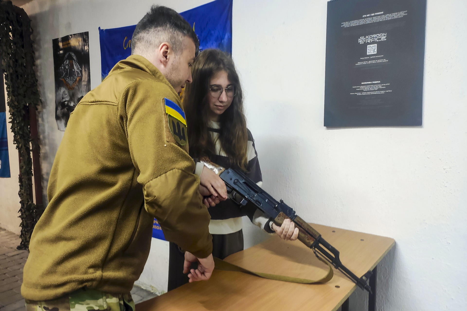 El instructor Yaroslav (i) ayuda a Anna, de 16 años, a aprender a montar una réplica de rifle durante una clase de entrenamiento militar este jueves, en Leópolis (Ucrania). A medida que la invasión rusa se acerca a su 52º mes, las escuelas secundarias ucranianas están pasando de las clases teóricas a la preparación militar práctica, con instructores con experiencia en combate que enseñan a los adolescentes habilidades básicas de combate y supervivencia. Más de 13.000 estudiantes de entre 15 y 17 años asisten a clases en más de una docena de centros especiales establecidos por las autoridades locales en Leópolis. El modelo de esta ciudad del oeste de Ucrania se está extendiendo ahora a todo el país, mientras el Estado prepara a una generación que podría enfrentarse a más años de conflicto. EFE/ Rostyslav Averchuk
