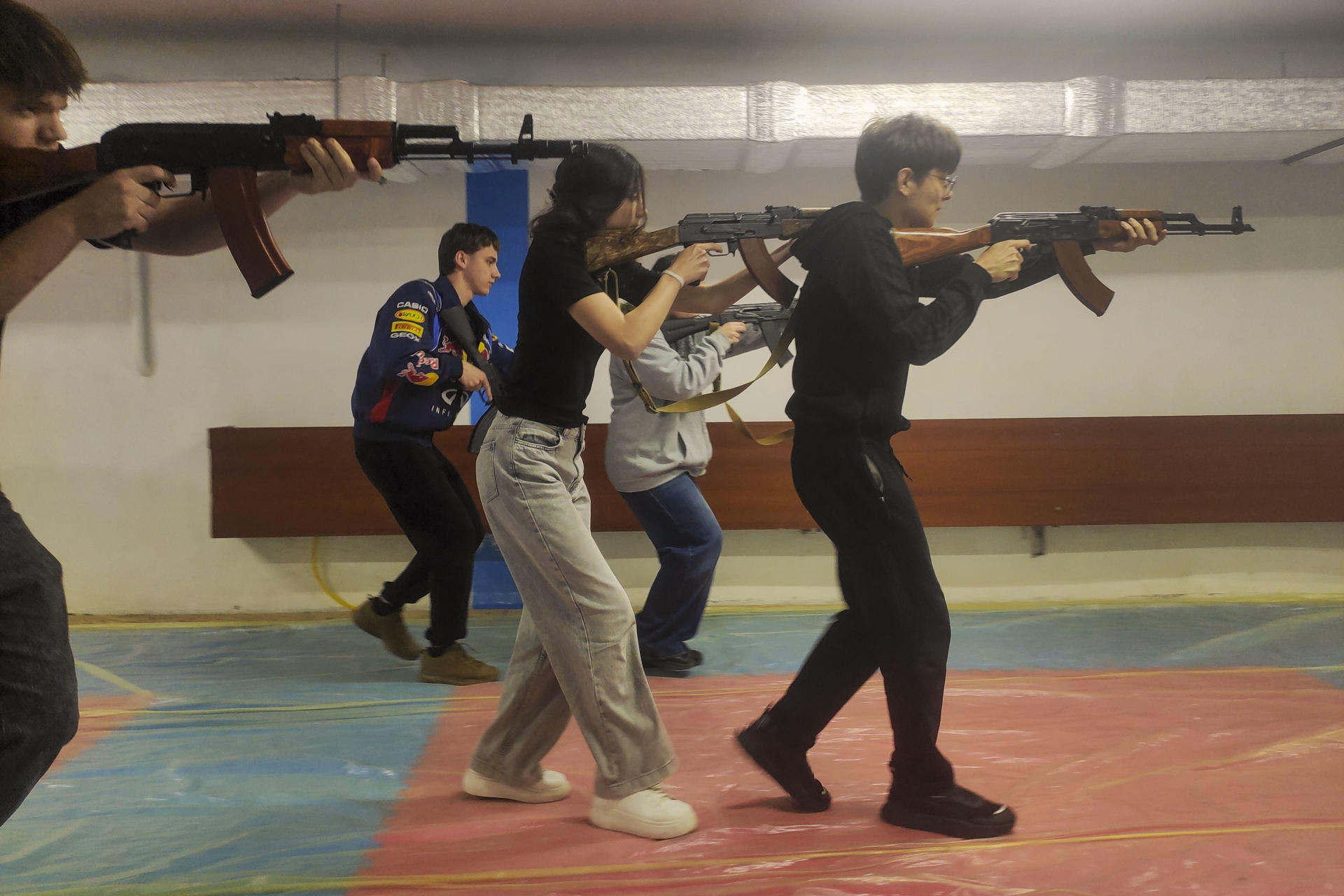 Estudiantes ucranianos de entre 15 y 17 años adquieren habilidades básicas en el manejo de armas bajo la supervisión de instructores con experiencia en combate este jueves, en una escuela de Leópolis (Ucrania). A medida que la invasión rusa se acerca a su 52º mes, las escuelas secundarias ucranianas están pasando de las clases teóricas a la preparación militar práctica, con instructores con experiencia en combate que enseñan a los adolescentes habilidades básicas de combate y supervivencia. Más de 13.000 estudiantes de entre 15 y 17 años asisten a clases en más de una docena de centros especiales establecidos por las autoridades locales en Leópolis. El modelo de esta ciudad del oeste de Ucrania se está extendiendo ahora a todo el país, mientras el Estado prepara a una generación que podría enfrentarse a más años de conflicto. EFE/ Rostyslav Averchuk

