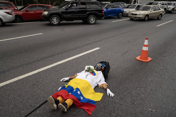 Una mujer se manifiesta en la autopista Francisco Fajardo para reclamar que se convoque a unas elecciones libres en el país, este jueves, en Caracas (Venezuela). EFE/ Ronald Peña R
