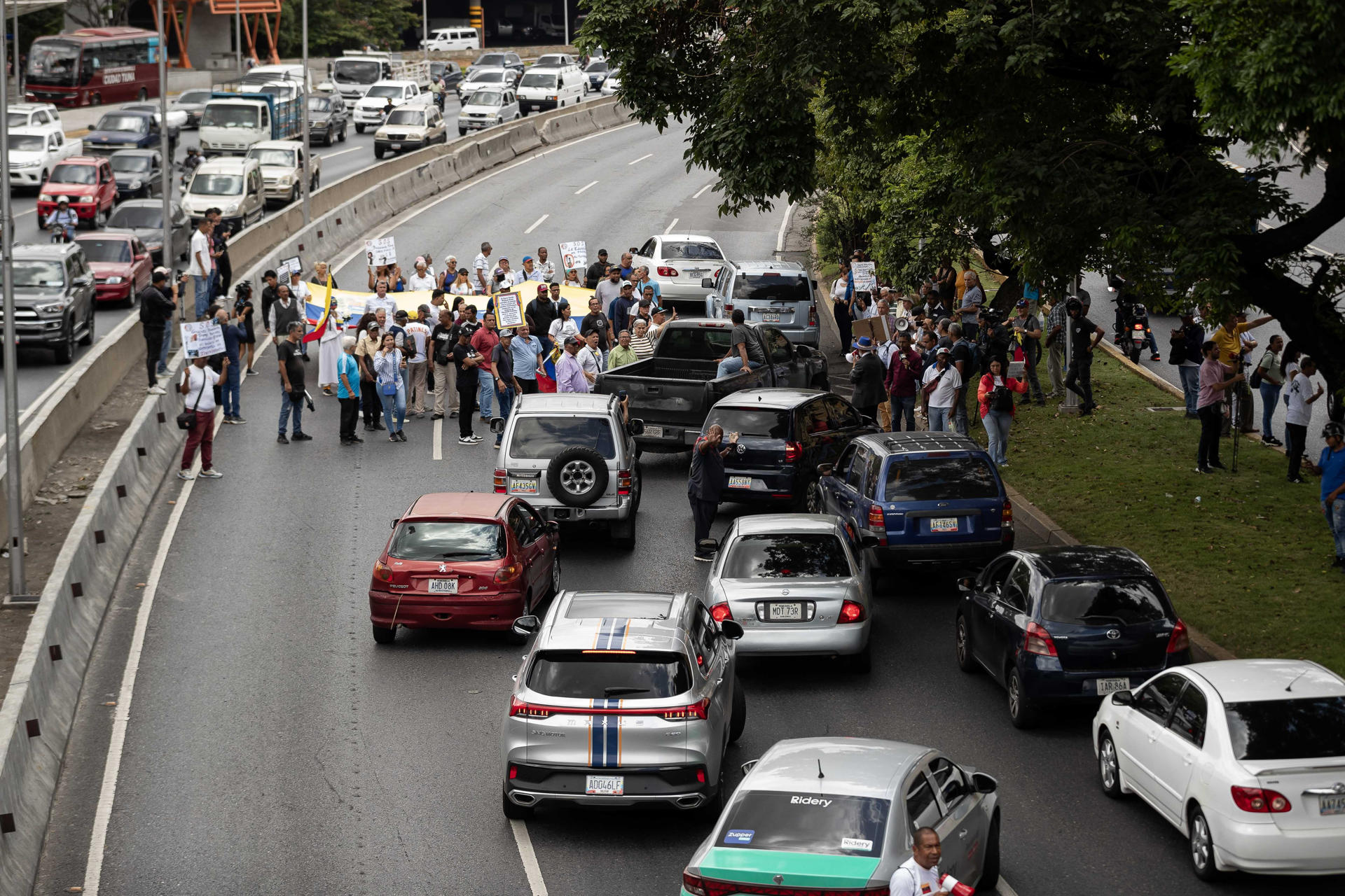 Personas trancan la autopista Francisco Fajardo en una manifestación para reclamar que se convoque a unas elecciones libres en el país, este jueves, en Caracas (Venezuela). EFE/ Ronald Peña R

