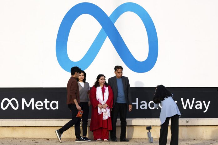Fotografía de archivo de un grupo de personas al posar para una foto con el logo de la compañía tecnológica estadounidense Meta de fondo, en Menlo Park (CA, EE.UU.). EFE/John G. Mabanglo
