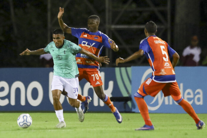 Robinson Flores (c), de Puerto Cabello, disputa el balón con Ramiro Peralta (i), de Juventud, este jueves en un partido de la Copa Sudamericana en el estadio Misael Delgado, en Valencia (Venezuela). EFE/ Juan Carlos Hernández
