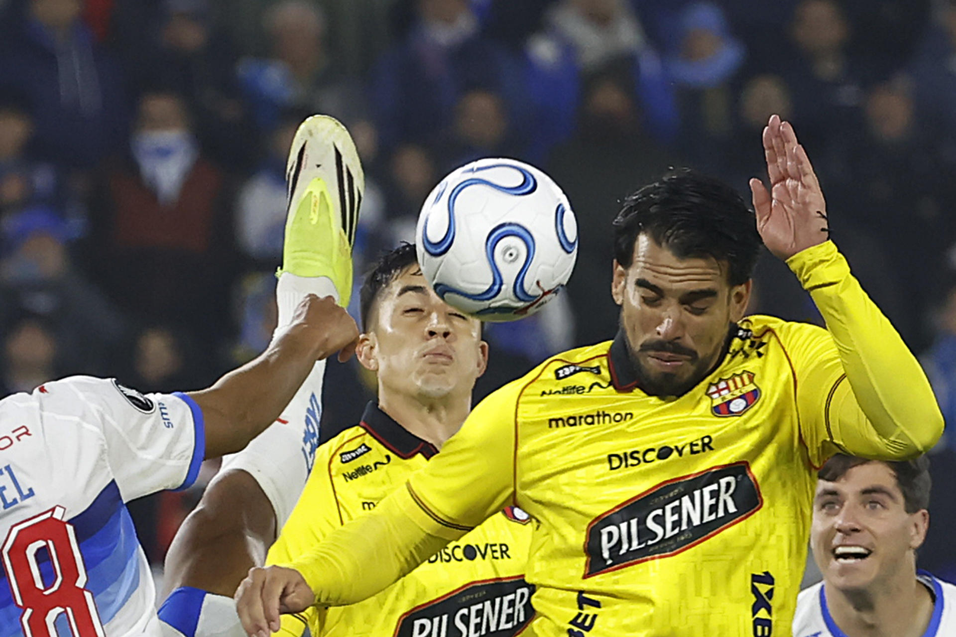 Juan Francisco Rossel (i) de la Universidad Católica disputa el balón con Cristian Báez de Barcelona este jueves, durante un partido de laquinta jornada de la fase de grupos de la Copa Libertadores jugado en el estadio Claro Arena de Santiago. EFE/ Elvis González
