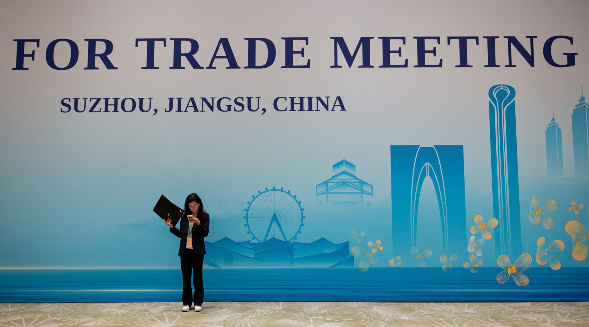 Una mujer delante del cartel la ceremonia de apertura de la reunión de la APEC en Suzhou, provincia de Jiangsu, China, 22 de mayo de 2026. EFE/EPA/ALEX PLAVEVSKI