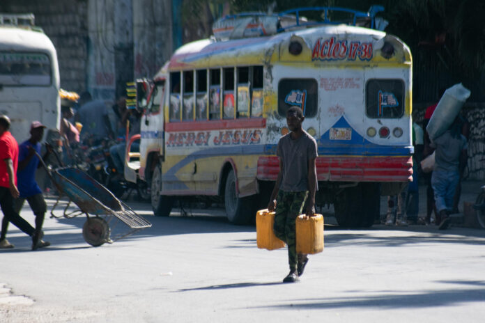 Una persona carga bidones con agua este jueves, en Puerto Príncipe (Haití). EFE/ Jonet St Élois
