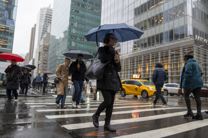 Personas caminan bajo la lluvia en Manhattan, en el centro de Nueva York (Estados Unidos). Imagen de archivo. EFE/ Ángel Colmenares.
