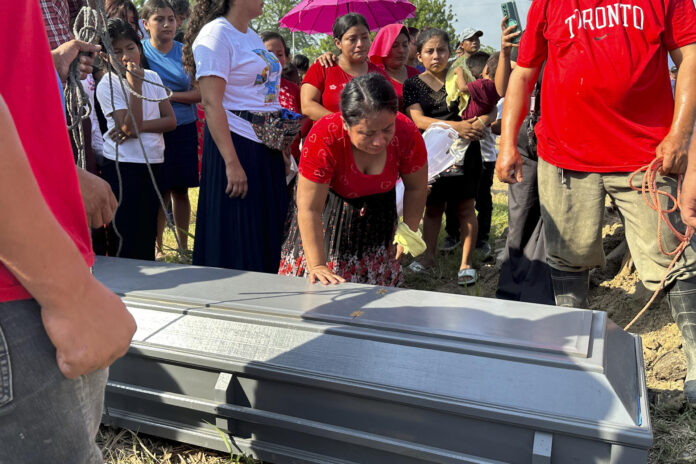Una mujer llora sobre un féretro durante el funeral de los hermanos Elmer y Wilmer Suchite en Rigores (Honduras). EFE/ Germán Reyes
