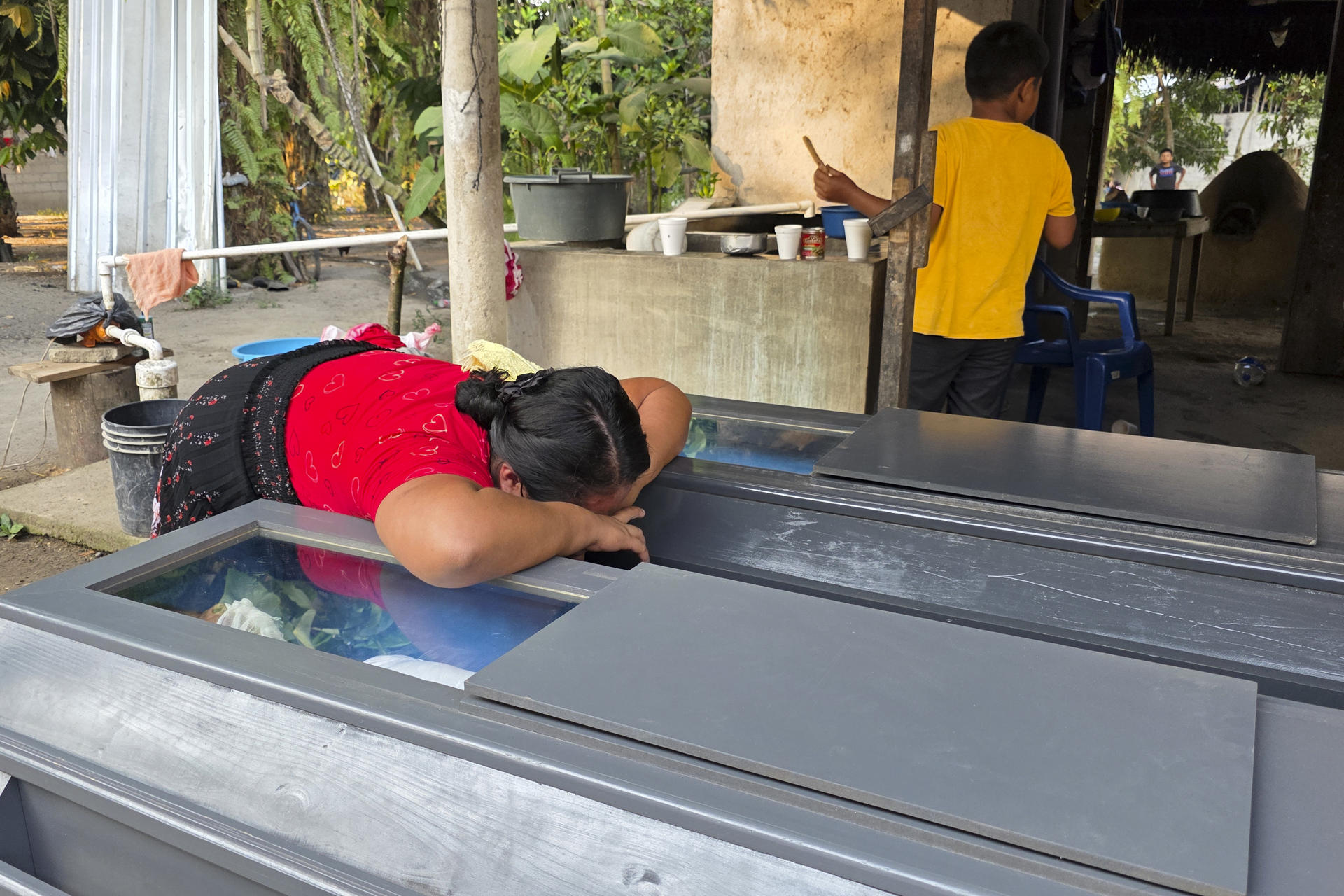 Una mujer llora sobre los féretros de los hermanos Elmer y Wilmer Suchite durante su velorio en Rigores (Honduras). EFE/ Germán Reyes
