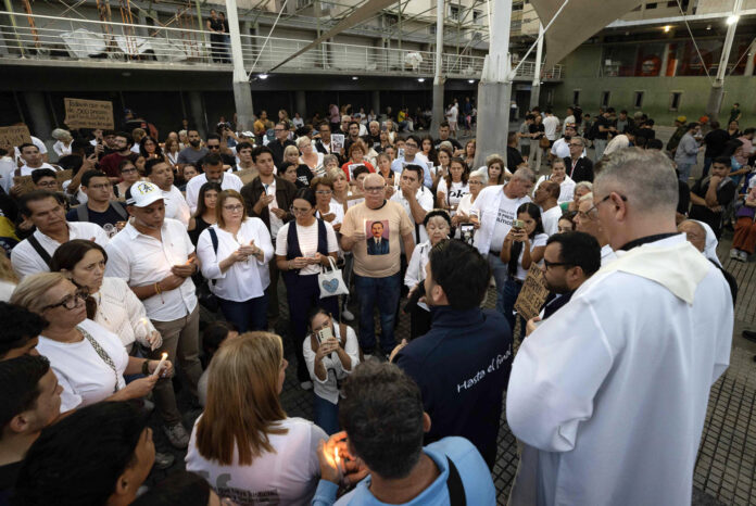Decenas de personas fueron captadas este 22 de mayo durante una vigilia en honor a Carmen Teresa Navas, la madre del preso político Víctor Quero Navas y quien falleció diez días después de que el Gobierno venezolano le confirmara la muerte de su hijo ocurrida hace más de diez meses y bajo custodia estatal, en Caracas (Venezuela). EFE/Ronald Peña
