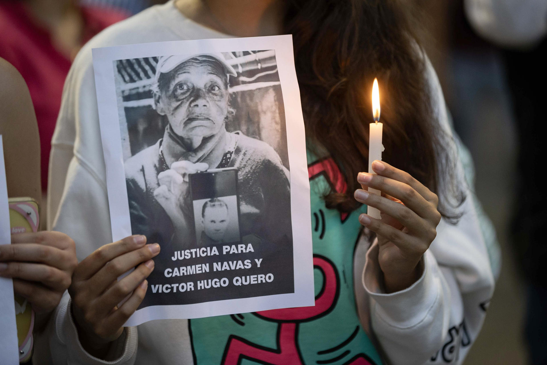 Detalle del torso de una joven que sostiene una vela y una fotografía de Carmen Teresa Navas, la madre del preso político Víctor Quero Navas y quien falleció diez días después de que el Gobierno venezolano le confirmara la muerte de su hijo ocurrida hace más de diez meses y bajo custodia estatal, durante un vigilia en honor a la mujer, en Caracas (Venezuela). EFE/Ronald Peña