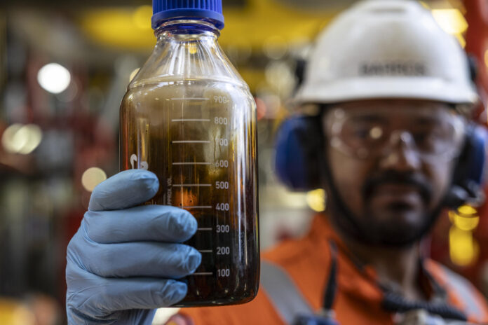 Fotografía de archivo en la que se captó a un trabajador de la petrolera estatal brasileña Petrobrás al sostener una muestra de petróleo crudo, en la unidad flotante de producción, almacenamiento y descarga (FPSO) Almirante Tamandaré, en la Cuenca de Santos, a 180 km de la costa de Río de Janeiro (Brasil). EFE/André Coelho

