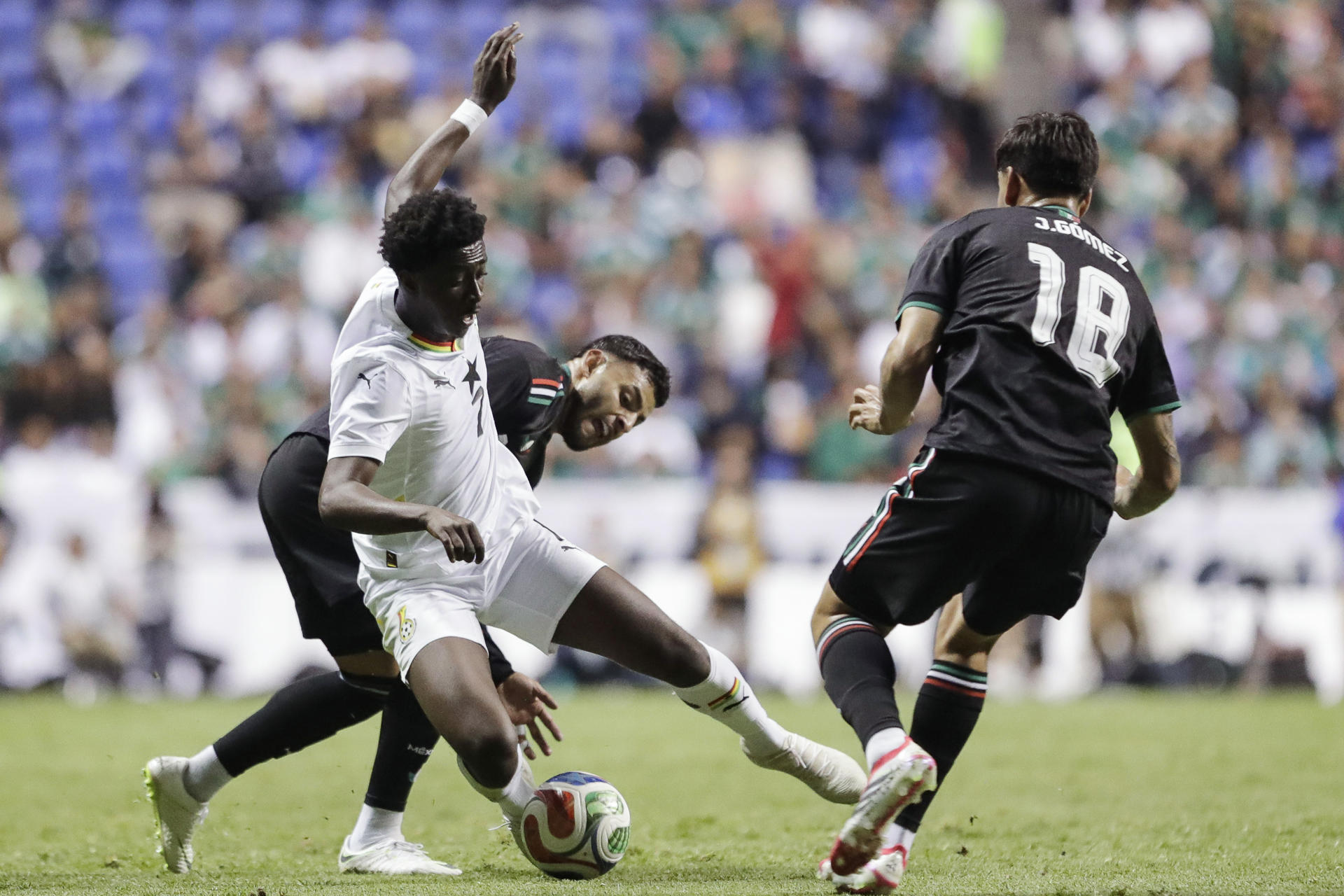 Alexis Ayala (i) y Jesús Gómez (d), de México, disputan el balón con Jesurun Rak-Sakyi, de Ghana, este viernes durante un partido amistoso en el estadio Cuauhtémoc, en Puebla (México). EFE/ Hilda Ríos
