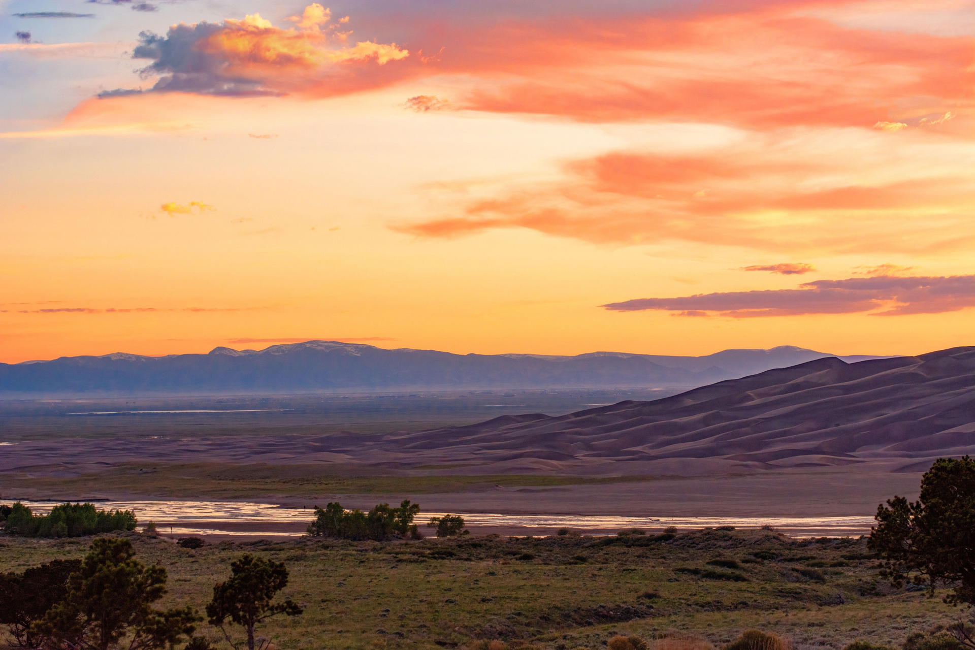 Fotografía divulgada por el Servicio de Parques Nacionales (NPS) de Estados Unidos que muestra un atardecer sobre Medano Creek, las dunas y el Valle de San Luis en Colorado (EE.UU.). EFE/ NPS
