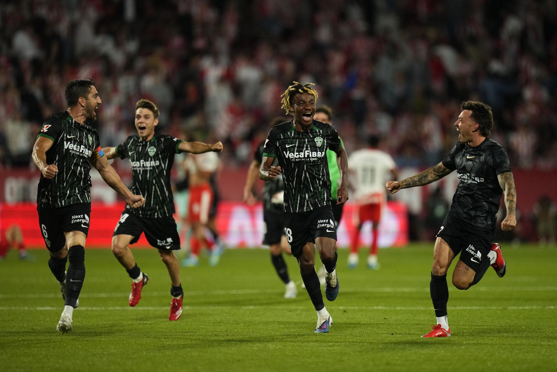 Los jugadores del Elche celebran la permanencia en Primera División al término del partido de la jornada 38 de la LaLiga EA Sports entre el Girona Fc y el Elche Fc disputado este sábado en el estadio municipal de Montilivi.- EFE/ Siu Wu
