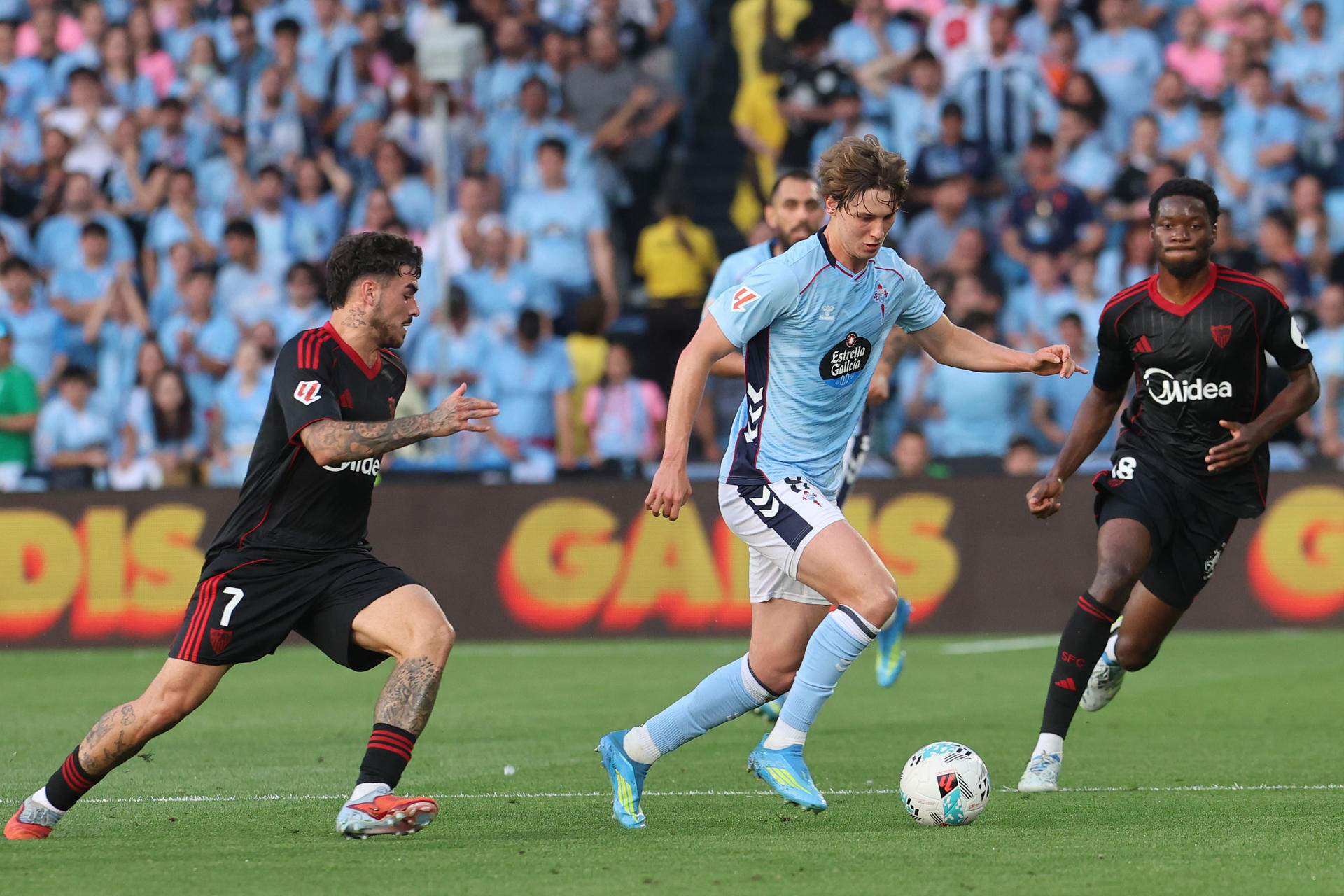 El jugador del Celta Fer López pugna por un balón con el jugador del Sevilla Isaac Romero, durante el partido dela jornada 38 de LaLiga, este sábado en el Estadio de Balaídos. EFE/ Salvador Sas