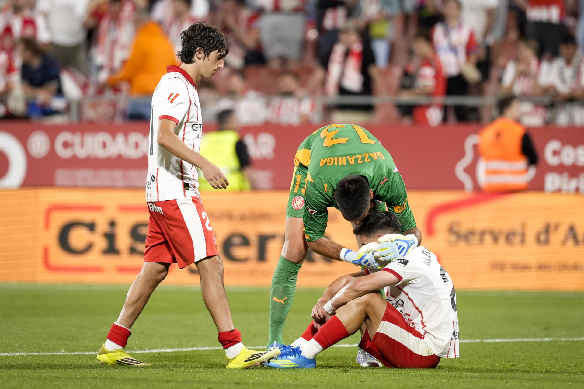 Los jugadores del Girona visiblemente afectados tras el descenso del equipo a Segunda División al término del partido de la jornada 38 de la LaLiga EA Sports entre el Girona Fc y el Elche Fc, este sábado en el estadio municipal de Montilivi.- EFE/ David Borrat
