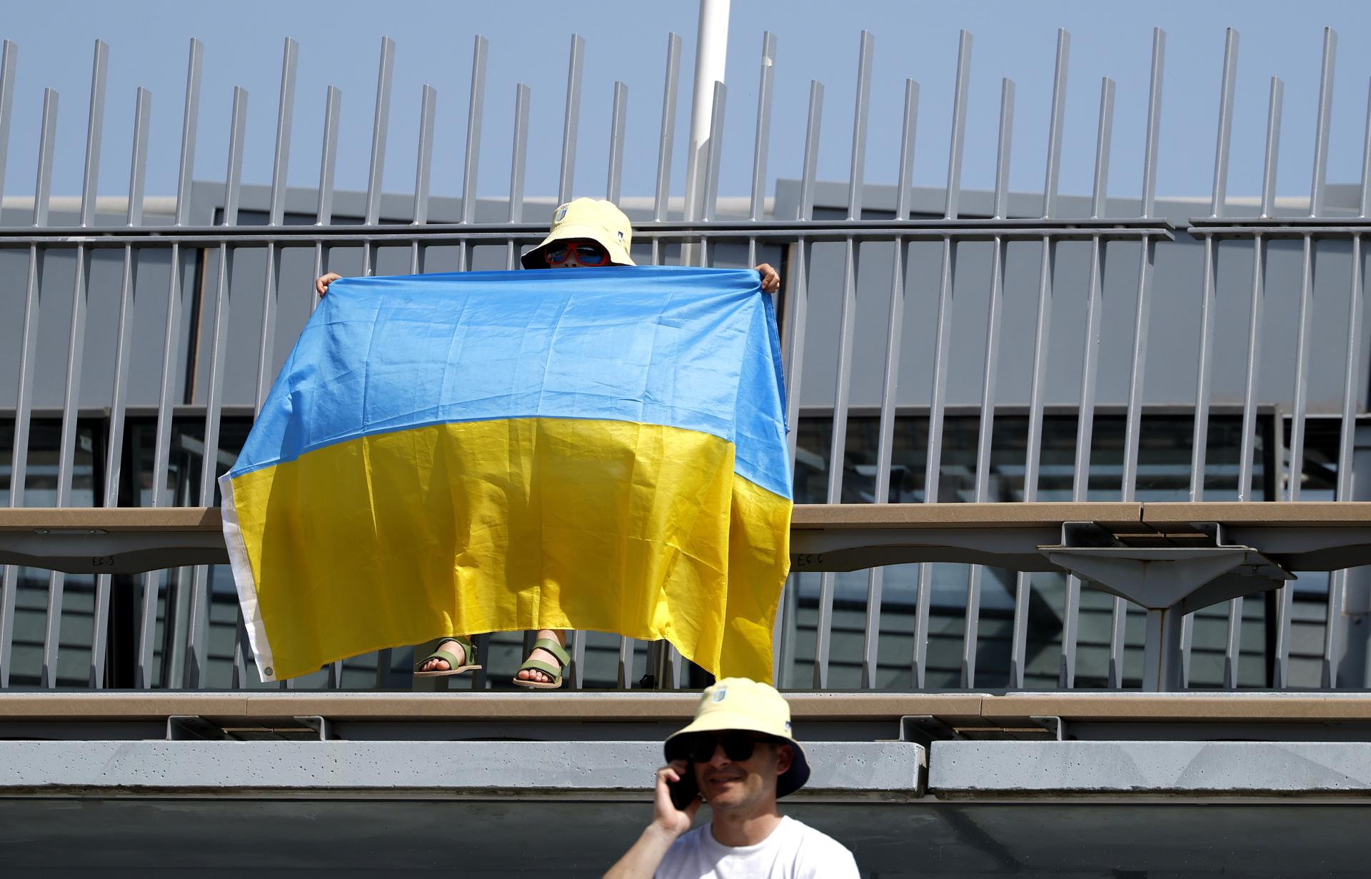 Un espectador exhibe una bandera de Ucrania este domingo, durante el partido de primera ronda de Roland Garros entre la ucraniana Marta Kostyuk y la española Oksana Selekhmeteva. EFE/YOAN VALAT