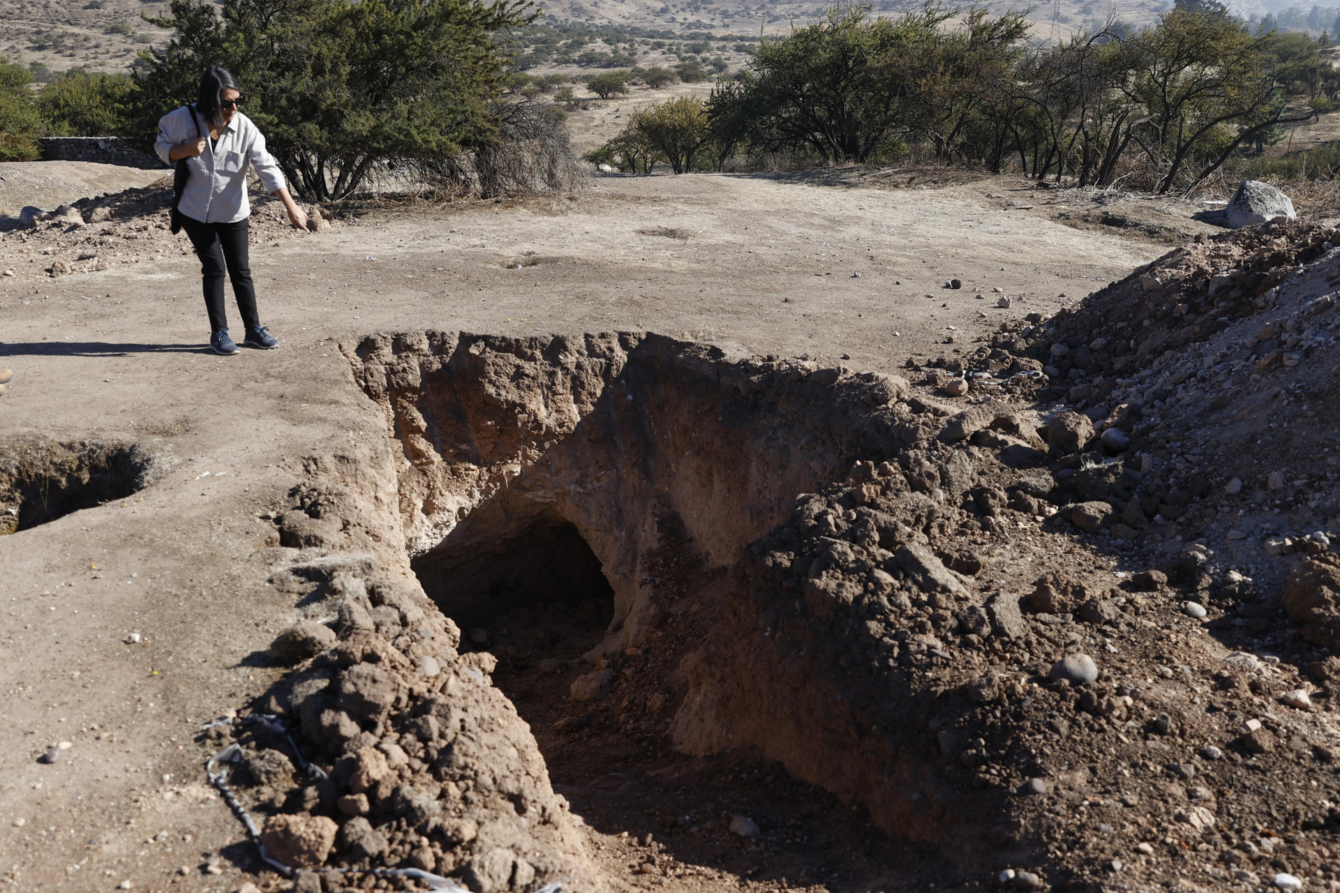 Fotografía del 11 de mayo 2026 en la que aparece la integrante de la Agrupación de Familiares de Ejecutados Políticos (AFEP), Mónica Monsalves, observa en Cerro Chena, el lugar donde fusilaron a su padre en 1973 y donde se realizan excavaciones para buscar un posible cementerio clandestino de la dictadura, en Santiago (Chile). EFE/ Elvis González