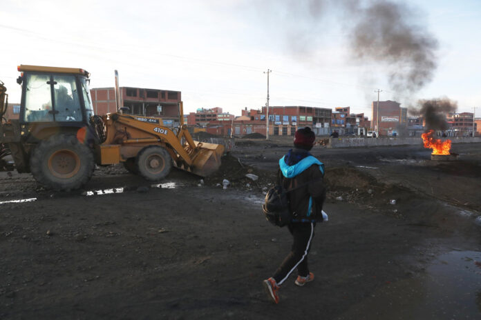 Tractores limpian escombros en la vía de La Paz con Oruro este sábado, en Ventilla (Bolivia). EFE/ Luis Gandarillas
