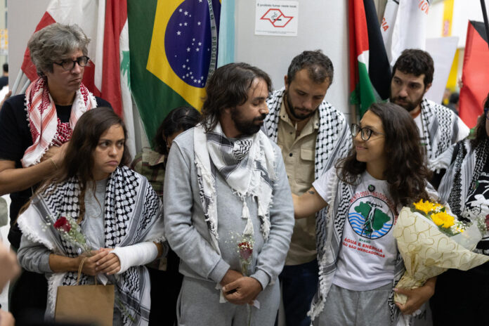 De izquierda a derecha, la activista Ariadne Teles, coordinadora de Global Sumud Brasil, el médico pediatra Cássio Pelegrini y la activista Beatriz Moreira, integrante del MAB (Movimiento de los Afectados por Represas), llegan este domingo, al Aeropuerto Internacional de Guarulhos (Brasil). Según los participantes de una misión humanitaria internacional con destino a la Franja de Gaza, la flotilla fue interceptada por la marina israelí en aguas internacionales. EFE/Isaac Fontana
