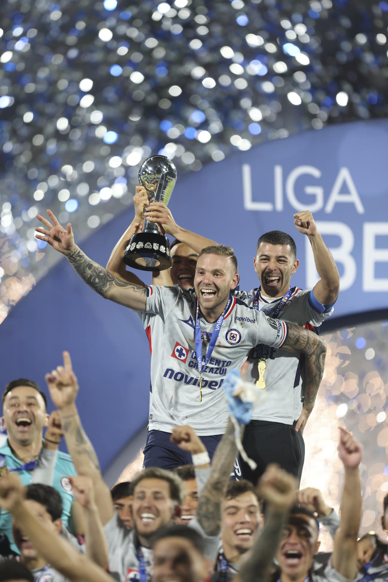 Carlos Rodríguez (atrás), Rodolfo Rotondi (frente) y Erick Lira (atrás) de Cruz Azul celebran con el trofeo de campeón este domingo en la final de la Liga MX ante Pumas, en el estadio Olímpico Universitario en la Ciudad de México (México). EFE/Isaac Esquivel
