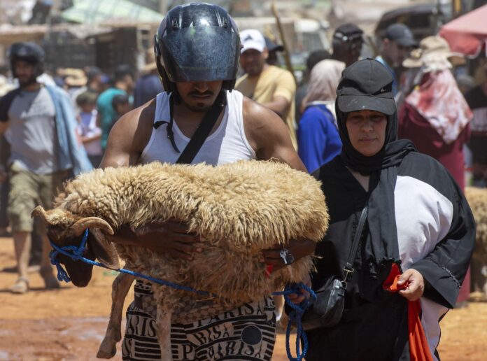 Un hombre carga el cordero que ha comprado en un mercado ganadero para la fiesta musulmana de Aid al-Adha, en Temara, Marruecos, el 24 de mayo de 2026 (publicado el 25 de mayo de 2026). EFE/EPA/JALAL MORCHIDI
