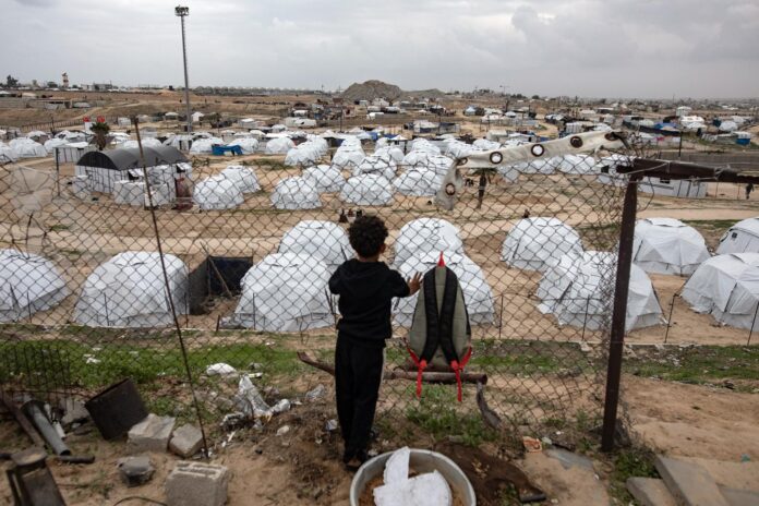 Un niño observa las tiendas de campaña dentro de un campamento en Jan Yunis, en el sur de la Franja de Gaza, en una fotografía de archivo. EFE/EPA/HAITHAM IMAD
