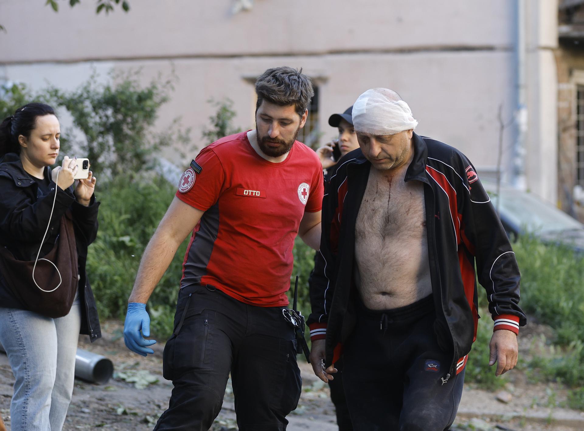 Un trabajador médico asiste a un residente herido en el lugar de un ataque ruso a un edificio residencial en Kiev, Ucrania, el 24 de mayo de 2026, en medio de la invasión rusa. Más de 600 drones y 90 misiles golpearon varios lugares en Kiev durante la noche del 24 de mayo, lo que provocó al menos dos muertes confirmadas y más de 80 heridos, según el presidente ucraniano Volodymyr Zelensky. (Rusia, Ucrania, Kiev) EFE/EPA/SERGEY DOLZHENKO
