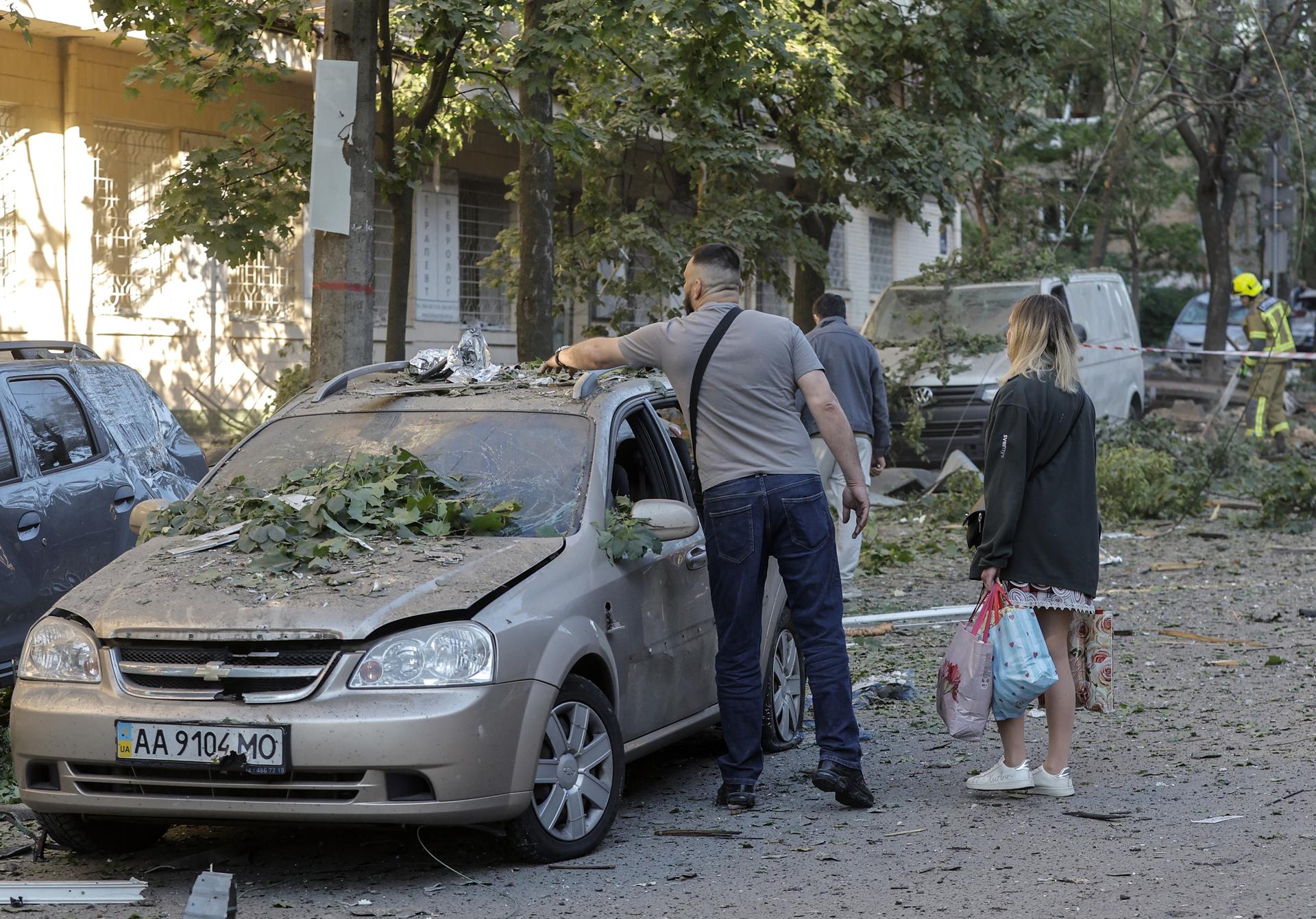 Residentes locales inspeccionan los daños en un vehículo en el lugar de un ataque ruso a un edificio residencial en Kyiv, Ucrania, el 24 de mayo de 2026, en medio de la invasión rusa. Más de 600 drones y 90 misiles alcanzaron varios lugares en Kyiv durante la noche del 24 de mayo, lo que provocó al menos dos muertes confirmadas y más de 80 heridos, según el presidente ucraniano Volodymyr Zelensky. (Rusia, Ucrania, Kiev) EFE/EPA/SERGEY DOLZHENKO
