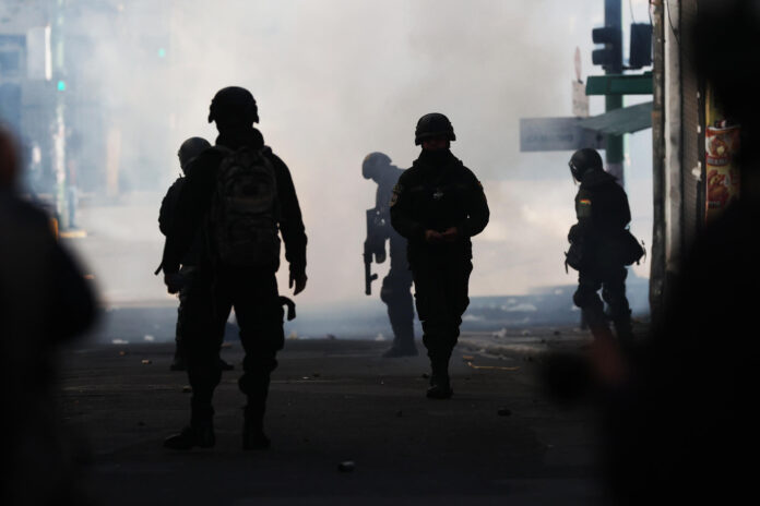 Integrantes de la Policía de Bolivia reaccionan durante una jornada de protestas que exigen la renuncia del presidente de Bolivia, Rodrigo Paz, este lunes en La Paz (Bolivia). EFE/ Luis Gandarillas
