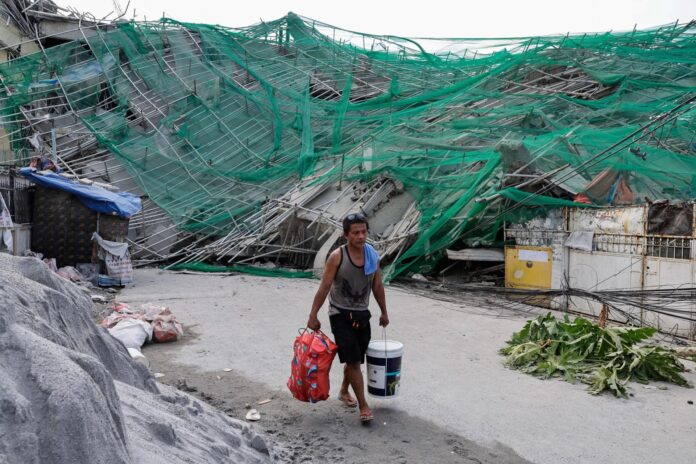ANGELES (Philippines), 25/05/2026.- Alfredo Albis, trabajador en el lugar del derrumbe de un edificio, transporta sus pertenencias entre los escombros en un distrito residencial de la ciudad de Ángeles, provincia de Pampanga, Filipinas, el 25 de mayo de 2026. 
EFE/EPA/ROLEX DELA PENA
