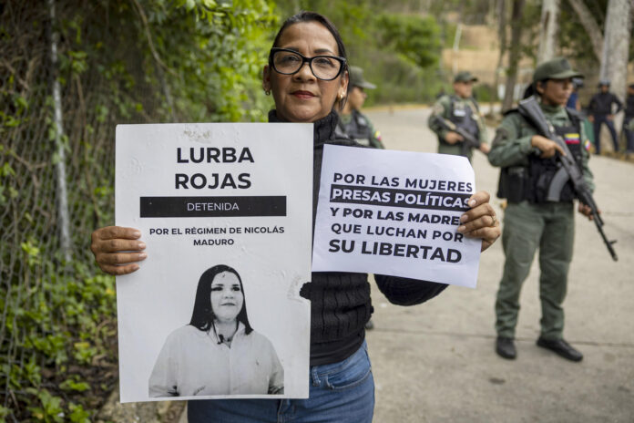 Una mujer sostiene carteles durante una manifestación en los alrededores del Instituto Nacional de Orientación Femenina (INOF) para exigir a la presidenta encargada de Venezuela, Delcy Rodríguez, la liberación de detenidas en Los Teques (Venezuela). EFE/ Miguel Gutiérrez
