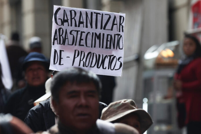 Una persona sostiene un cartel durante una marcha para exigir al gobierno soluciones ante los bloqueos y el desabastecimiento este martes, en La Paz (Bolivia). EFE/ Luis Gandarillas
