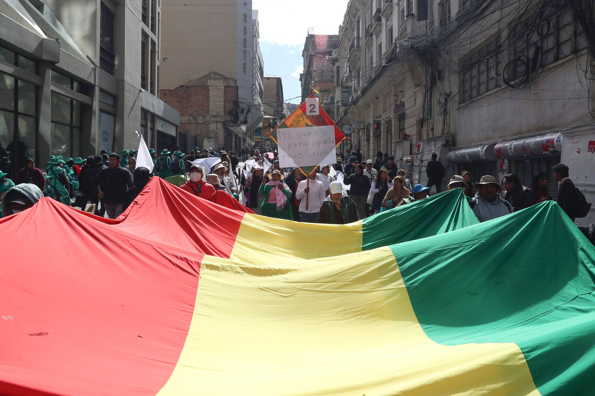 Personas ondean una bandera de Bolivia durante una marcha para exigir al gobierno soluciones ante los bloqueos y el desabastecimiento este martes, en La Paz (Bolivia). EFE/ Luis Gandarillas
