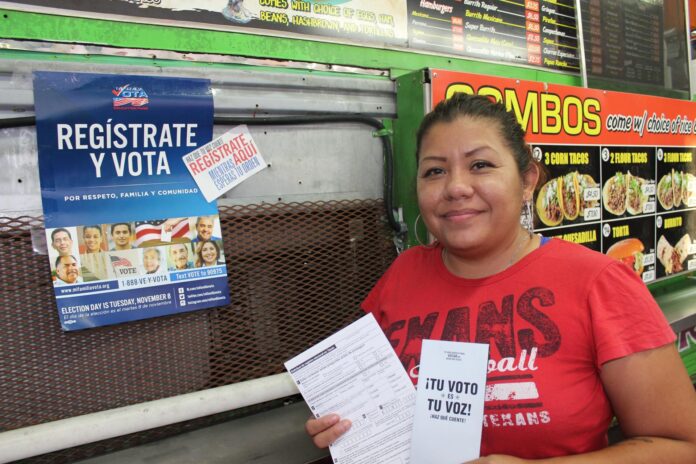 La ciudadana naturalizada Cristina Gutiérrez muestra unos folletos con información sobre la registración para votar junto al puesto de tacos Taconmadr, en el sureste de Houston, Texas. Imagen de archivo. EFE/Yanet Pintor
