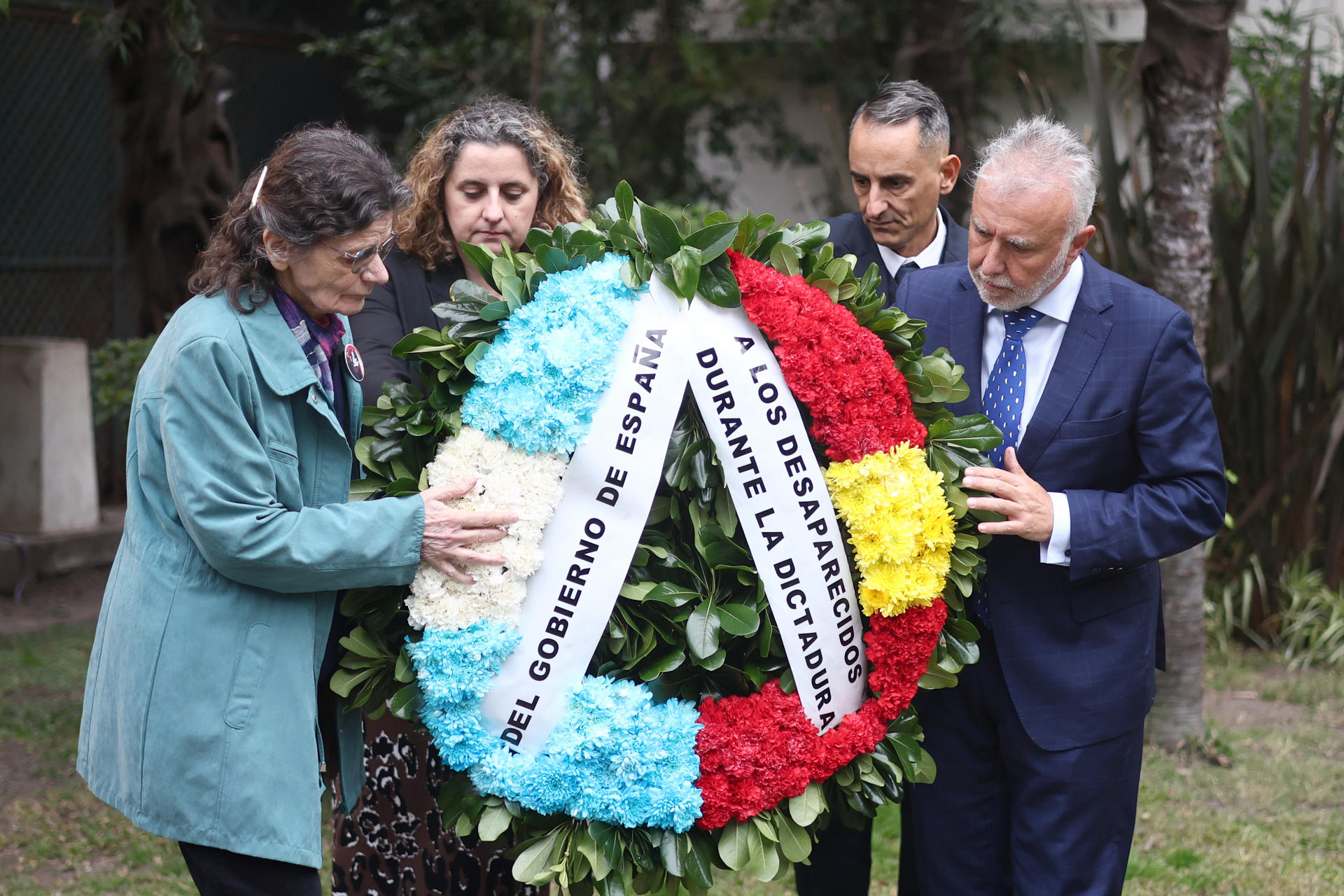El ministro de Política Territorial y Memoria Democrática de España, Angel Víctor Torres (d), y la presidenta de la Comisión de Españoles Desaparecidos durante la dictadura en Argentina (1976-1983), María Consuelo Castaño (i), sostienen un ramo de flores en un homenaje a los 307 españoles desaparecidos durante la dictadura este martes, en Buenos Aires (Argentina). EFE/ Juan Ignacio Roncoroni
